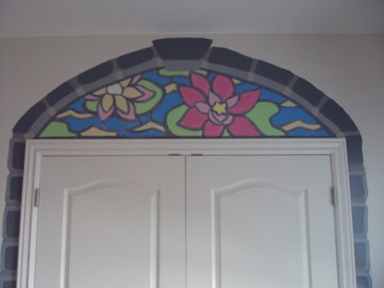 Above a closet door is a painting of a stained glass window with a flower and lily pad.