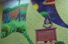 Dinosaurs, space, and a studious student painted on a tile wall