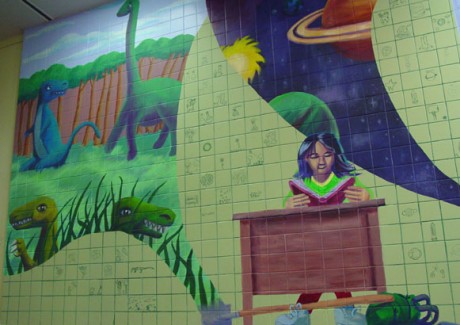 Dinosaurs, space, and a studious student painted on a tile wall